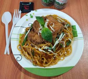 Spaghetti pasta in spicy tomato olive sauce with fried chicken