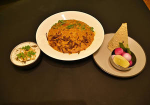 Masala Khichdi Served With Papad And Raita