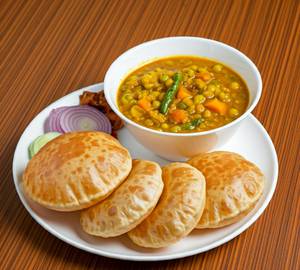 Luchi (04 Nos) served with Cholar Dal, Pickle, Curd, Chutney & Salad.