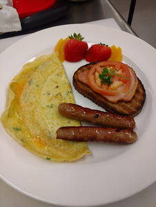 Omelette With 2 Chickens Sausages One Aloo Tikki Served With Toast