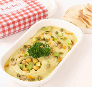 Avocado Hummus Topped With Seeds And Mixed Greens