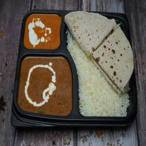 Dal Makhni, Paneer Butter Masala, Tawa Roti (4), Rice, Salad & Raita Thali