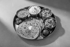 4 roti(ghee) 2 sabji ( subject to availability) Dal rice ,  sweet(1)  salad (onion tomata)