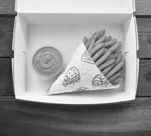 A Box Of Classic French Fries With Cajun Dip