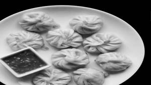 Steamed Momo In Molten Cheese Sauce